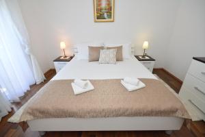 een slaapkamer met een groot bed en 2 handdoeken bij Apartman Viktoria in Rakovica
