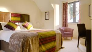 Habitación de hotel con cama y silla en Great Southern Killarney Holiday Homes, en Killarney