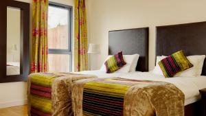a bedroom with two beds and a window at Self Catering Holiday Homes Killarney Town Centre in Killarney