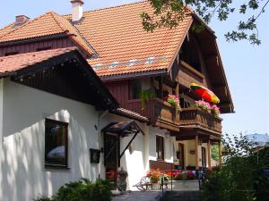 a house with a balcony with flowers on it at Hotel zum Zauberkabinett in Bad Heilbrunn