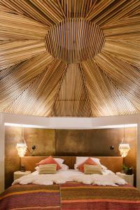 a bedroom with a large bed with a wooden ceiling at Hotel Desertica in San Pedro de Atacama