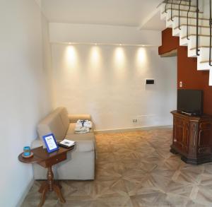 Armonie di Villa Incontri B&B في فلورنسا: غرفة معيشة مع أريكة وطاولة