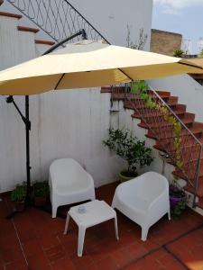 2 stoelen en een gele parasol op een patio bij Casa Castellano in Nola