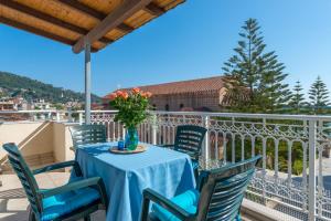 a table with chairs and a vase of flowers on a balcony at Indigo Zante Home in Zakynthos