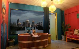 a room with a tub with a view of the city at Artistic and Quirky Home with a Copper Bath and Complimentary Snack in Bangkok