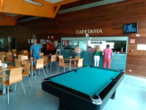 a group of people standing around a pool table at Lélé in Vila Praia de Âncora
