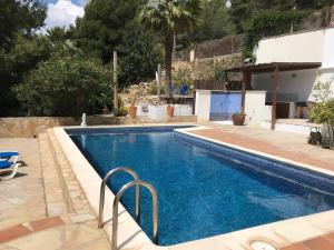 a swimming pool with blue water in a house at Casa Mallarenga Rooms in Olivella