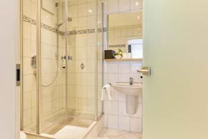 a bathroom with a shower and a sink at Hotel Restaurant Sonne in Gengenbach +59 photos