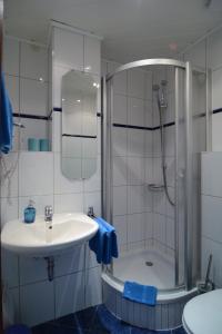 a white bathroom with a sink and a shower at Weinhaus Thomas in Klotten