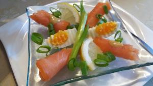 a plate of food with salmon and green onions at Motel in Teterow