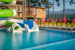 a swimming pool with chairs and a water slide at SPA Hotel Elbrus in Velingrad