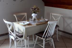 a white table with chairs and a vase of flowers at Apartman Ivana in Varaždin