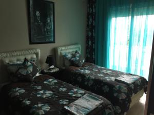 a bedroom with two beds and a window at Résidence Dreamland in Sidi Rahal +78 photos