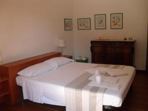 ein Schlafzimmer mit einem weißen Bett und einem Handtuch darauf in der Unterkunft i gù books & rooms in Polignano a Mare