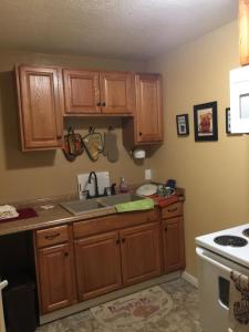 a kitchen with a sink, stove, cabinets and a refrigerator at Economy Guest Village in Rock Springs