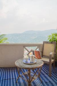 康提的住宿－Holiday Stay Inn，阳台上的桌子和两杯咖啡