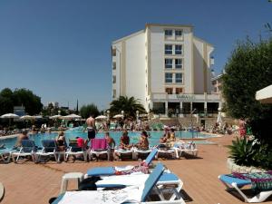 a group of people sitting in lawn chairs by a pool at Ourabay Hotel Apartamento - Art & Holidays in Albufeira