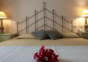 a bed with a white bedspread and pillows at Hotel Monti Di Mola in Porto Cervo