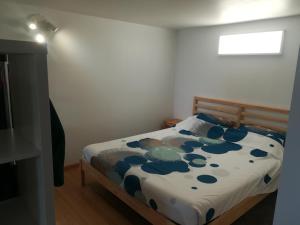 ein Schlafzimmer mit einem Bett mit blauen Blumen darauf in der Unterkunft Le willou in Malmedy