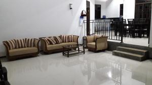 a living room with couches and a table and stairs at Kottamba Yala Stay & Safari in Tissamaharama