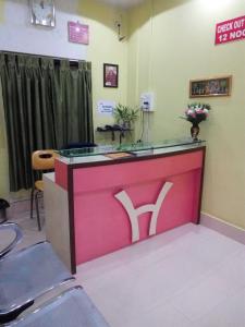 a waiting room with a pink counter with a sign at Sewak Lodge in Silchar