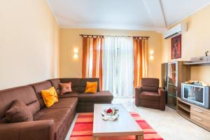 a living room with a couch and a tv at Apartments Lucie in Premantura