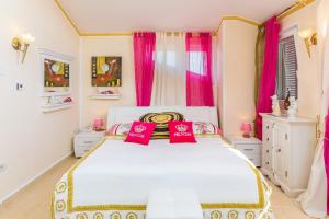 a bedroom with a white bed with red pillows at Apartments Lucie in Premantura