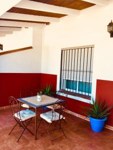 een tafel en stoelen in een kamer met een raam bij Los Candiles in Conil de la Frontera