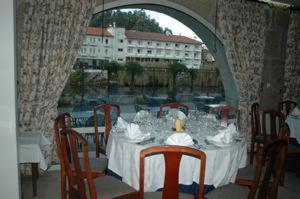 a dining room table with a white table cloth and chairs at Hotel Rural Villa do Banho in Termas de Sao Pedro do Sul