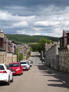 a street in a small town with cars parked at Dunvegan Bed & Breakfast in Dufftown