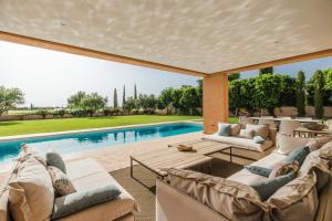 uma sala de estar exterior com uma piscina e mobiliário em Al Maaden 132 - Luxury front line golf villa with heated pool em Marraquexe