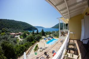 a balcony with a view of a pool and the ocean at Filoxenia in Yenion