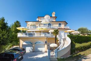 a villa with a car parked in front of it at Apartments Lucie in Premantura