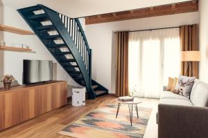 a living room with a couch and a staircase at Conrad's Mountain Lodge in Silvaplana