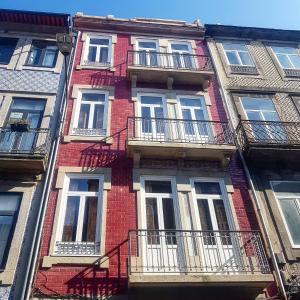 un edificio de ladrillo rojo con ventanas y balcones blancos en Step In Porto Apartments, en Oporto