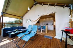 a living room with blue chairs and a couch at Krk glamping village in Krk