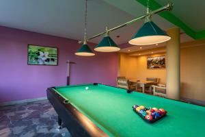 a pool table in a living room with lights at Hotel Góralski Raj in Nowy Targ