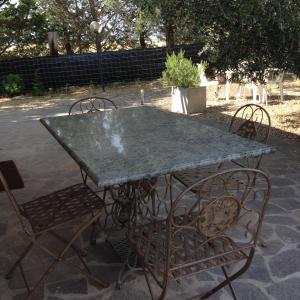 uma mesa de metal e cadeiras com uma mesa e cadeiras de betão em Agriturismo La Carletta em Preselle