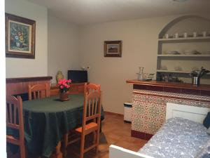 a dining room with a table and chairs and a kitchen at Las Olivas in Candeleda