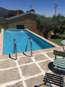 - une piscine avec deux rails métalliques à côté d'une maison dans l'établissement Las Olivas, à Candeleda