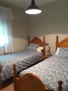 ein Schlafzimmer mit zwei Betten und einer Lampe in der Unterkunft Las Olivas in Candeleda