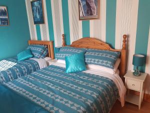 2 camas en un dormitorio con rayas azules y blancas en Sleepy Hollow B&B en Donegal