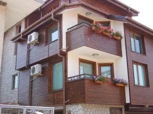 a building with a balcony with flowers on it at Dari Guest Rooms Стаи за гости Дари in Nesebar
