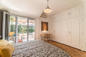 Schlafzimmer mit einem Bett und einer Glasschiebetür in der Unterkunft Le Berlioz in Nizza
