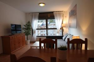 a living room with a table and a couch and a window at Pont de Toneta 1,3 Ransol, Zona Grandvalira in Ransol