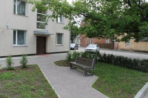a park bench sitting on a sidewalk next to a building at AMRAI Karamella in Ventspils
