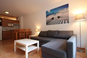 sala de estar con sofá, mesa y cocina en Pont de Toneta 1,4 Ransol, Zona Grandvalira, en Ransol