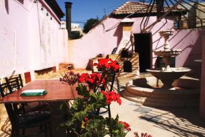 a patio with a table and red flowers and a fountain at Cairwan Hotel in Kerak