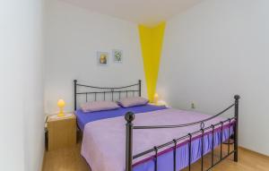 1 dormitorio con 1 cama grande con sábanas moradas en Apartments Lily, en Valbandon