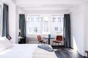 een slaapkamer met een bed en 2 stoelen en een tafel bij Svala Apartments by Heimaleiga in Reykjavík